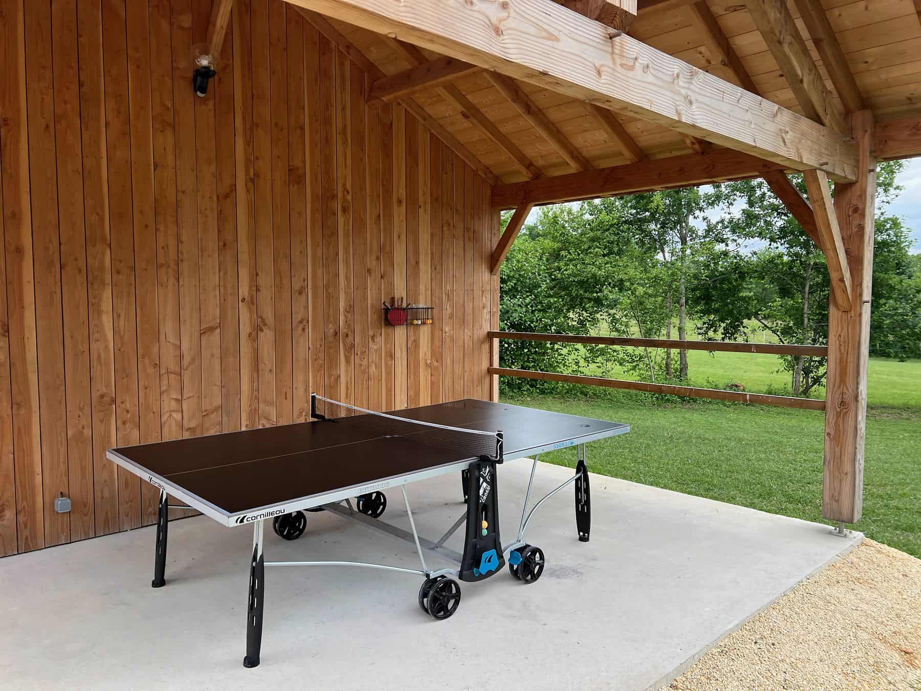 Table de ping-pong sous le préau, jeux en famille au gîte Les Terrasses
